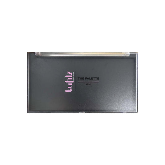 An empty magnetic palette with a gray lid, branded with the name 'THE PALETTE' in purple lettering.